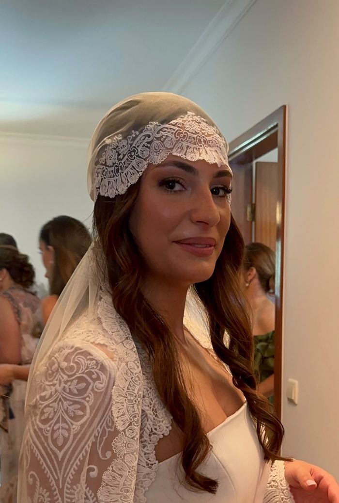A noiva Ana de véu de renda, a sorrir junto ao espelho